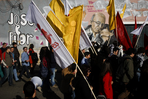 Workers wave flags and march in front of a Jose Saramago and Pilar del Rio graffiti tribute, in a recent protest against government austerity measures. Workers wave flags and march in front of a Jose Saramago and Pilar del Rio graffiti tribute, in a recent protest against government austerity measures.