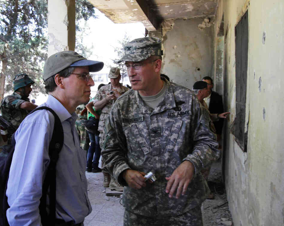 Robert Ford (left), the U.S. ambassador to Syria, speaks to an unidentified U.S. military attache during a guided government tour in the northern Syrian town of Jisr al-Shughur last June. The U.S. has closed its embassy in Syria owing to security concerns, but Ford is using Facebook to stay involved in the country.