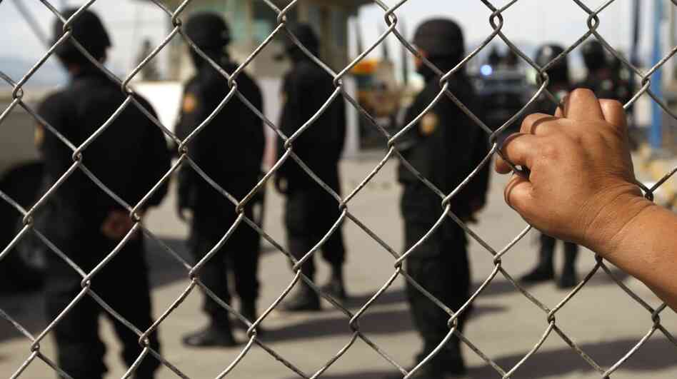 A relative of an inmate observes Mexican police behind the security fence after a riot inside Apodaca prison near Monterrey. At least 44 inmates were killed during Sunday's riot, and about 30 alleged members of the drug cartel Los Zetas were rushed out of the prison. A relative of an inmate observes Mexican police behind the security fence after a riot inside Apodaca prison near Monterrey. At least 44 inmates were killed during Sunday's riot, and about 30 alleged members of the drug cartel Los Zetas were rushed out of the prison.