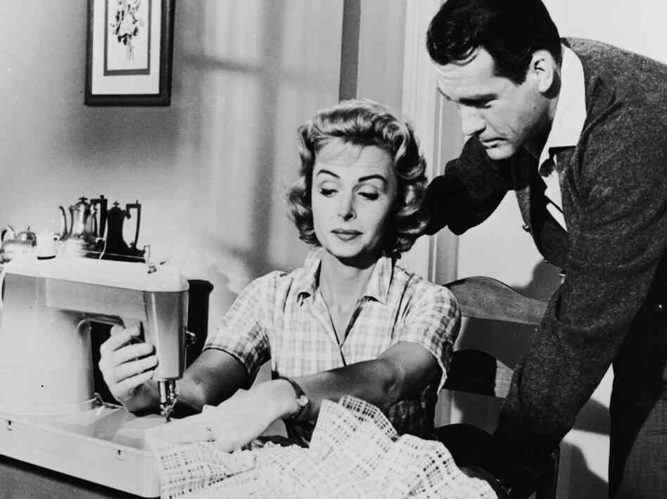 American actress Donna Reed sews on sewing machine as American actor Carl Betz watches over her shoulder American actress Donna Reed sews on sewing machine as American actor Carl Betz watches over her shoulder