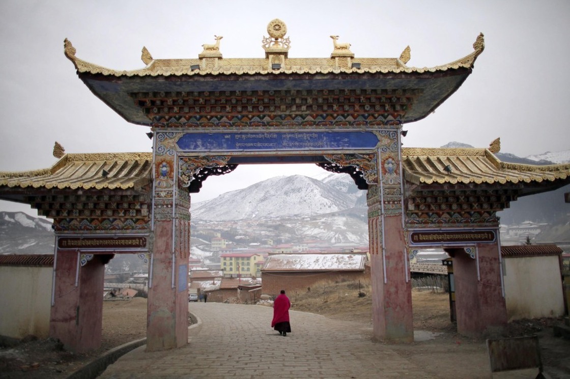 A monk walks under a temple entrance during Tibetan New Year celebrations in Langmusixiang, in China's western Sichuan Province Feb. 22, 2012. 