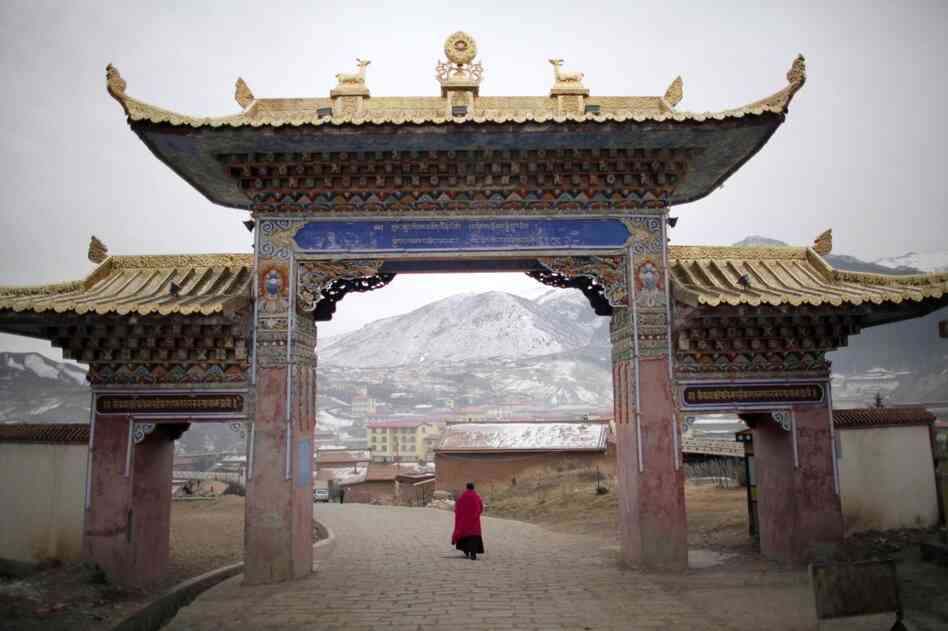 A monk walks under a temple entrance during Tibetan New Year celebrations in Langmusixiang, in China's western Sichuan Province Feb. 22, 2012. 