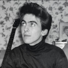 A young George Harrison and his many guitars. A young George Harrison and his many guitars.