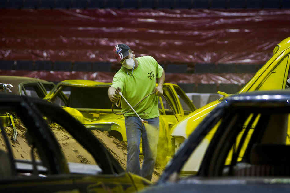 After laying down a 10,000-yard stockpile of dirt with an 8- to 10-inch base, the constructing of the obstacles begin. Junkyard cars from towing companies are brought to the arena and painted over with vibrant colors to enhance the audience experience.
