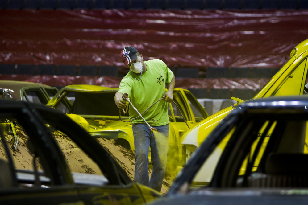 After laying down a 10,000-yard stockpile of dirt with an 8- to 10-inch base, the constructing of the obstacles begin. Junkyard cars from towing companies are brought to the arena and painted over with vibrant colors to enhance the audience experience.