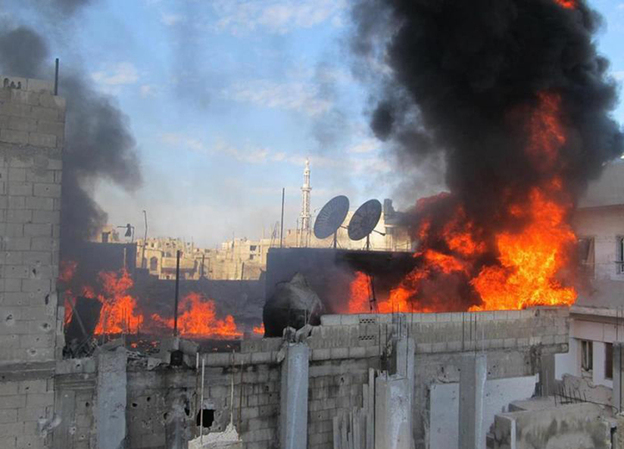 A handout picture released by Local coordination Committees in Syria (LCC Syria) on Feb. 22 shows fire on the roof of a building in the Baba Amr neighborhood of the flashpoint city of Homs.