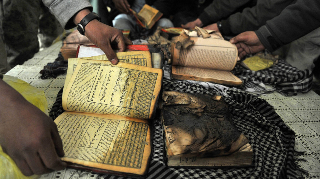 On Feb. 21 outside Bagram Airfield, Afghan demonstrators show copies of Qurans allegedly set on fire by U.S. soldiers at a NATO airbase outside Kabul.