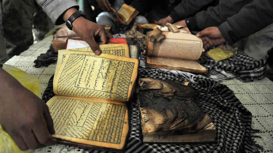 On Feb. 21 outside Bagram Airfield, Afghan demonstrators show copies of Qurans allegedly set on fire by U.S. soldiers at a NATO airbase outside Kabul.