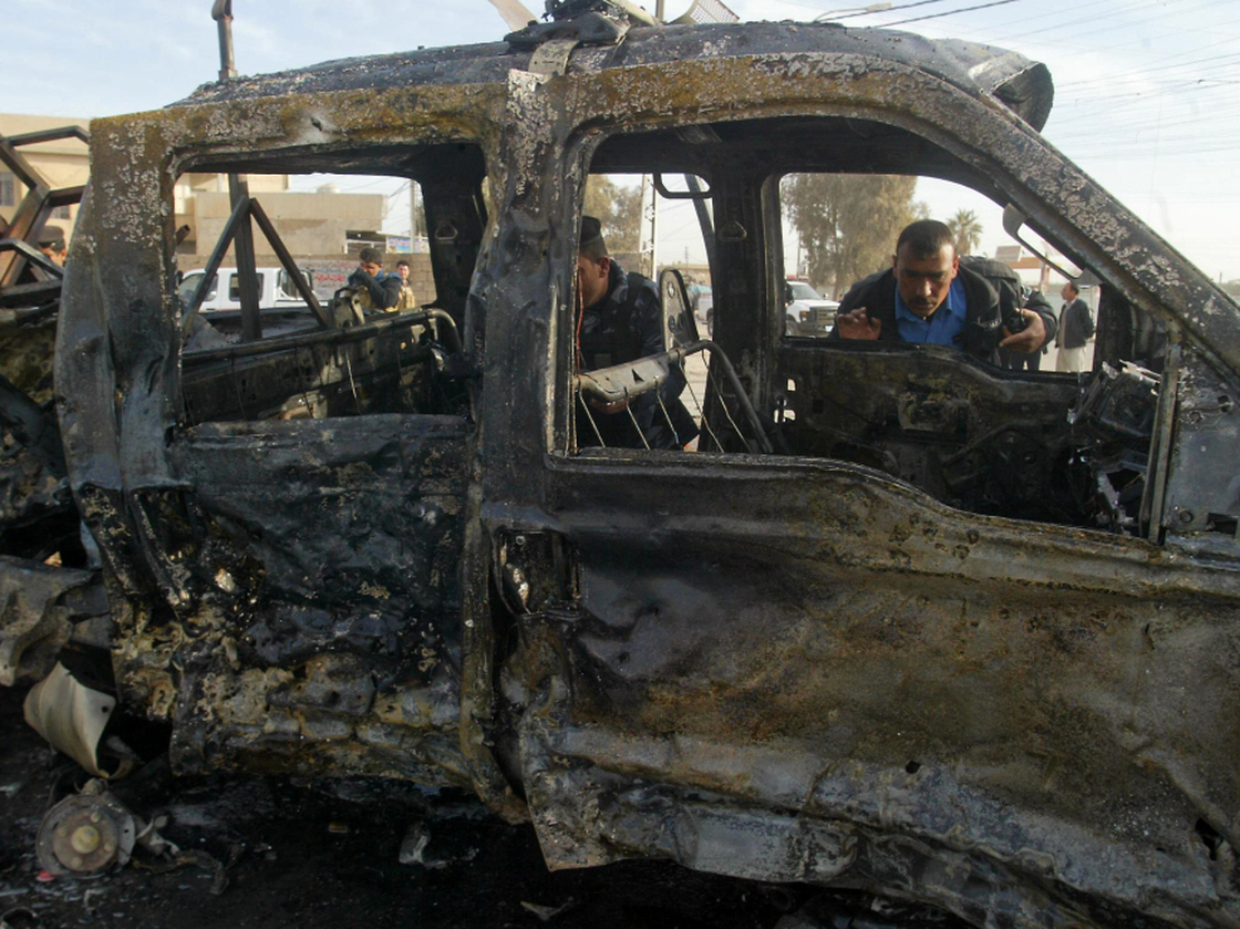 An Iraqi policeman inspects a destroyed vehicle at the site of a blast in the northern city of Kirkuk earlier today (Feb. 23, 2012).