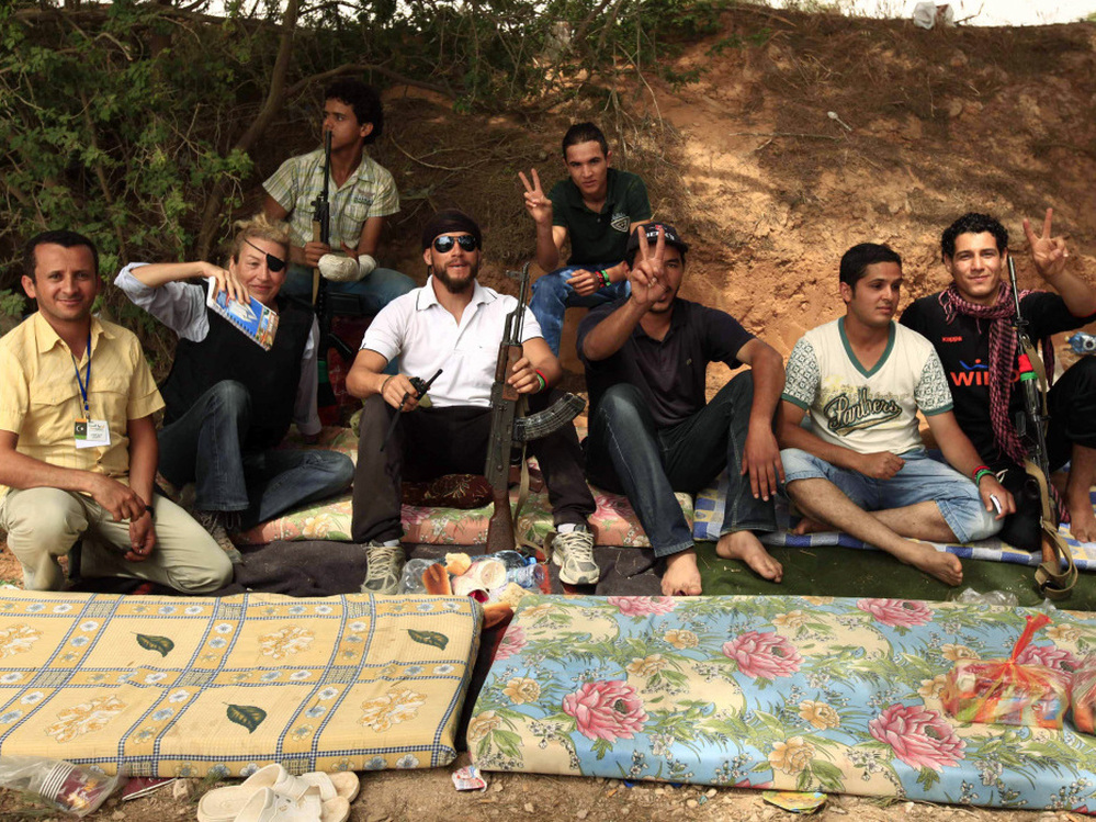 Journalist Marie Colvin (second from left) poses with Libyan rebels in Misrata on June 4, 2011. She was killed in the besieged Syrian city of Homs on Wednesday. Later that day in Tripoli, fellow war correspondents gathered to remember her.