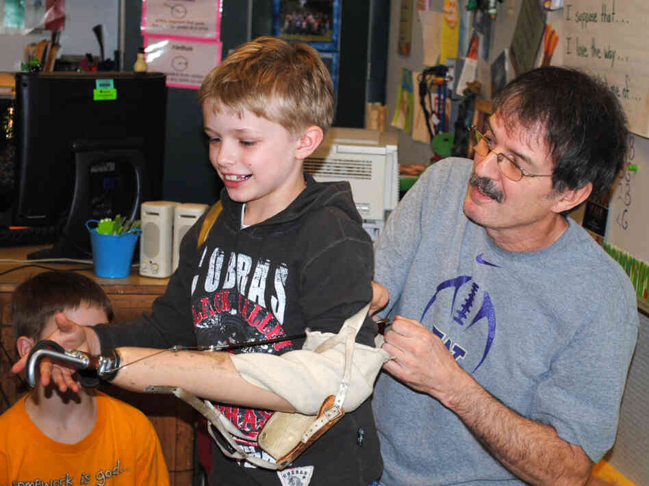 Ron Cushman's 8-year-old grandson, Shaun, tries out his grandfather's prosthetic arm. Cushman would let his students try out the arm on the first day of school.