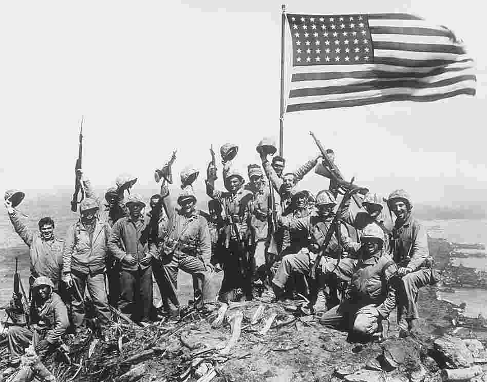 U.S. Marines cheer after raising the American flag on Iwo Jima. U.S. Marines cheer after raising the American flag on Iwo Jima.