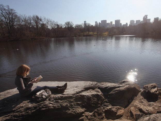 A woman takes in the sunshine while reading in Central Park on Feb. 1 in New York City, where temperatures topped 60 degrees.