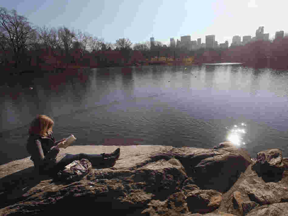 A woman takes in the sunshine while reading in Central Park on Feb. 1 in New York City, where temperatures topped 60 degrees.