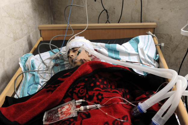 Zouheir Jabbour says many of the videos and images coming out of Syria are a fabrication. Here, a badly injured man lies in a bed at a makeshift clinic in the Syrian city of Idlib on Friday.