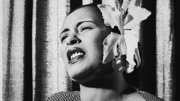 American blues singer Billie Holiday singing with an orchid in her hair.