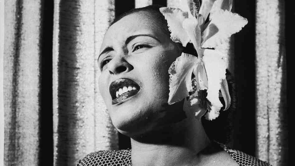 American blues singer Billie Holiday singing with an orchid in her hair.