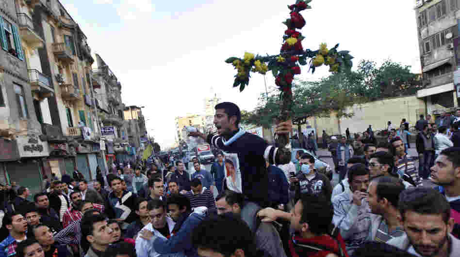 A Coptic Christian man holds a cross made of flowers during a clash between Christians and Muslims in Cairo in November. Relations are becoming more strained between the two communities, and there has been periodic violence.
