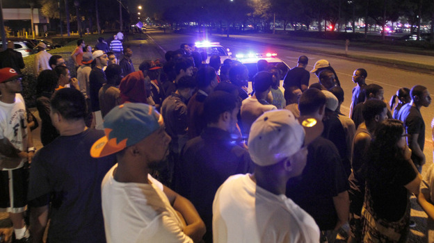 Police hold back crowds near The Florida Mall in Orlando, Fla. late Thursday.