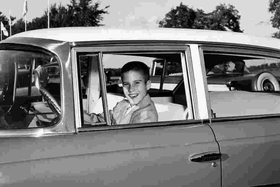 A young Mitt sits behind the wheel of his father's Rambler. 