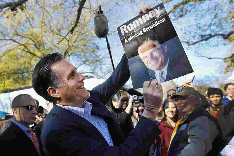 Mitt Romney holds a poster of his father, given to him at a campaign rally in Spartanburg, S.C., in January. 