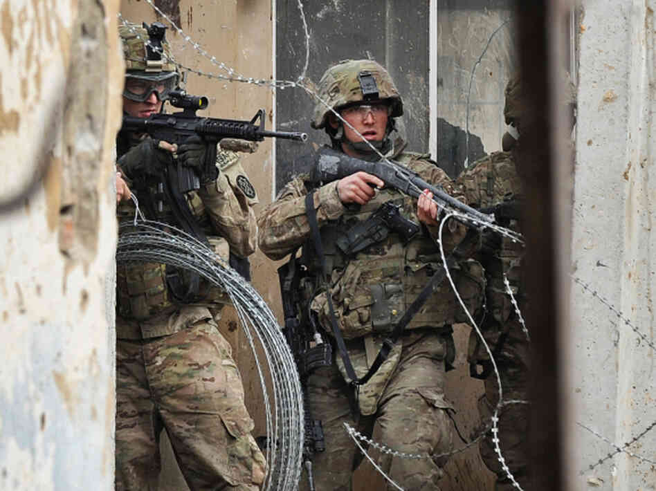 Two U.S. troops guard the gate at the Bagram Air Field north of Afghanistan's capital, Kabul, on Feb. 21. U.S. officials say troops inadvertently burned Qurans at the base, which has touched off violent protests around the country. 