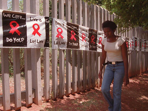 A woman walks past a banner placed around the perimeter of the Rand Afrikaans University in Johannesburg on World AIDS Day. The university used the banner to raise public awareness about AIDS and the devastating toll the disease has had in South Africa. A woman walks past a banner placed around the perimeter of the Rand Afrikaans University in Johannesburg on World AIDS Day. The university used the banner to raise public awareness about AIDS and the devastating toll the disease has had in South Africa.