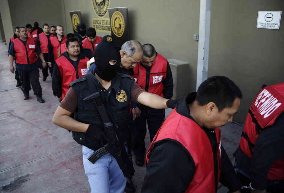 The warden and guards of the Apodaca prison are escorted away after a press conference in Monterrey, Mexico, Feb. 22. The director, deputy director and the chief of security along with 26 guards are under arrest for allegedly assisting members of the Zetas drug cartel orchestrate an escape and the killing of members of the rival Gulf cartel.