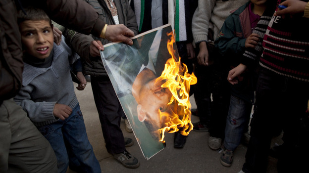 A man burns a portrait of Syrian President Bashar Assad during a Sunday demonstration on the outskirts of Idlib in northern Syria. 