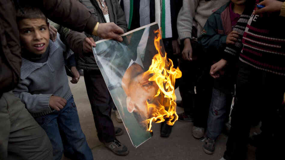 A man burns a portrait of Syrian President Bashar Assad during a Sunday demonstration on the outskirts of Idlib in northern Syria. 