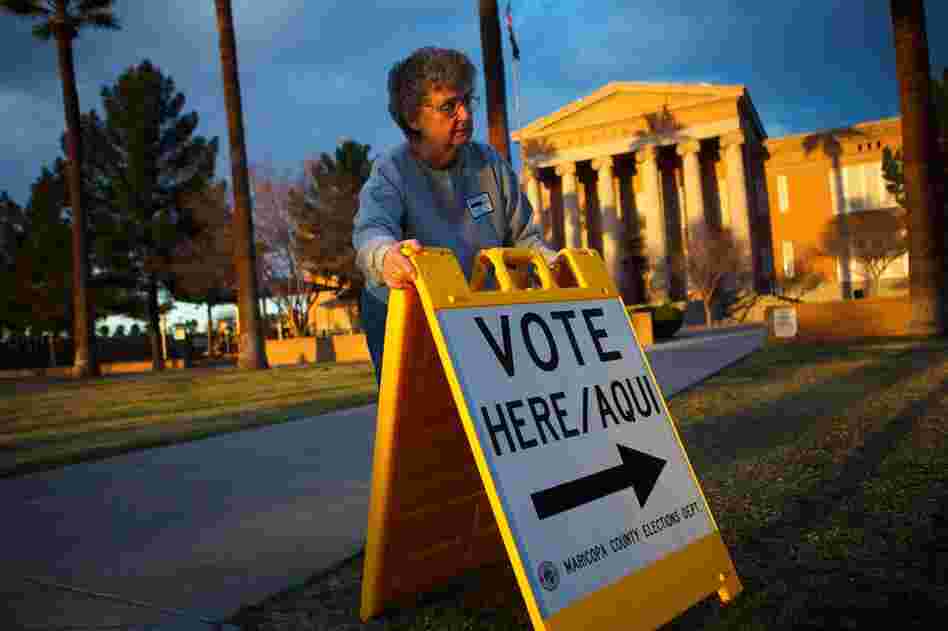 Volunteer Vicki Groff points voters to the polls in Phoenix. Romney won 47.3 percent of the vote in Arizona; Santorum got 26.6. 