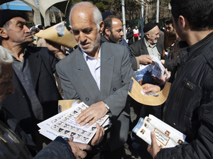 An Iranian man passes out election leaflets after Friday prayers in Tehran last week. An Iranian man passes out election leaflets after Friday prayers in Tehran last week.