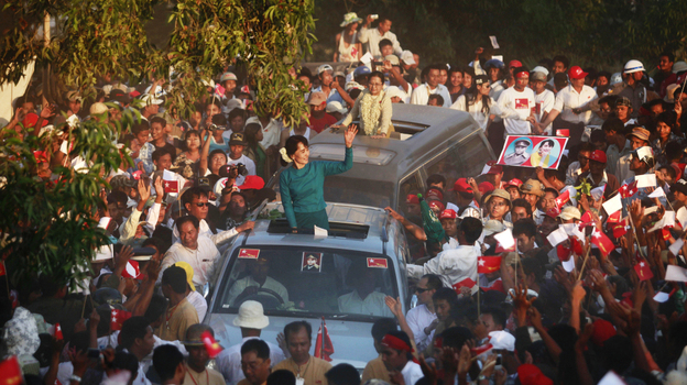 Supporters greet Myanmar's pro-democracy icon Aung San Suu Kyi, atop her vehicle, as she arrives at an election campaign rally in Thongwa village, Myanmar, on Sunday. The country's new government is holding legislative elections on April 1.