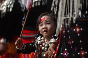 A girl from the Kachin ethnic group waves the flag of Suu Kyi's National League for Democracy as the democracy leader arrives in Namti village last week. A girl from the Kachin ethnic group waves the flag of Suu Kyi's National League for Democracy as the democracy leader arrives in Namti village last week.