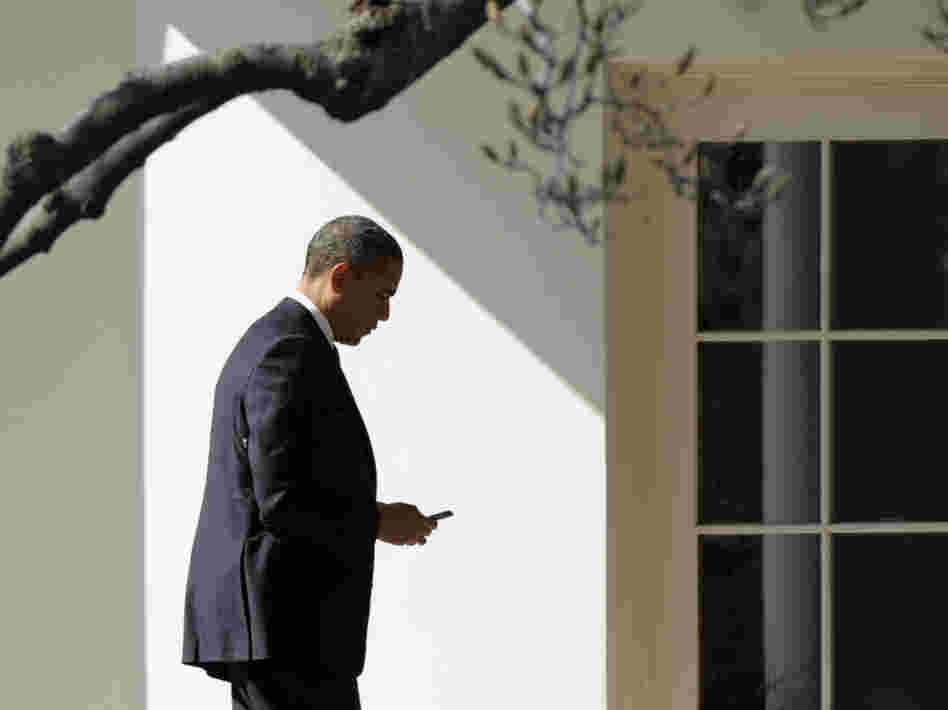 President Obama appears to check smartphone as he heads for the Oval Office after speaking to the UAW, Tuesday, Feb. 28, 2012.