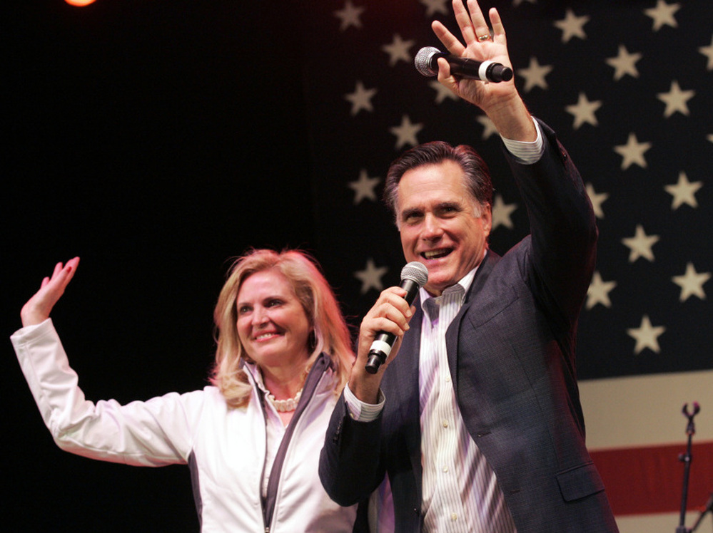 In a final bit of campaigning before Tuesday's vote, Mitt Romney and his wife, Ann, wave to his supporters during a campaign stop in Royal Oak, Mich., on Monday night. 