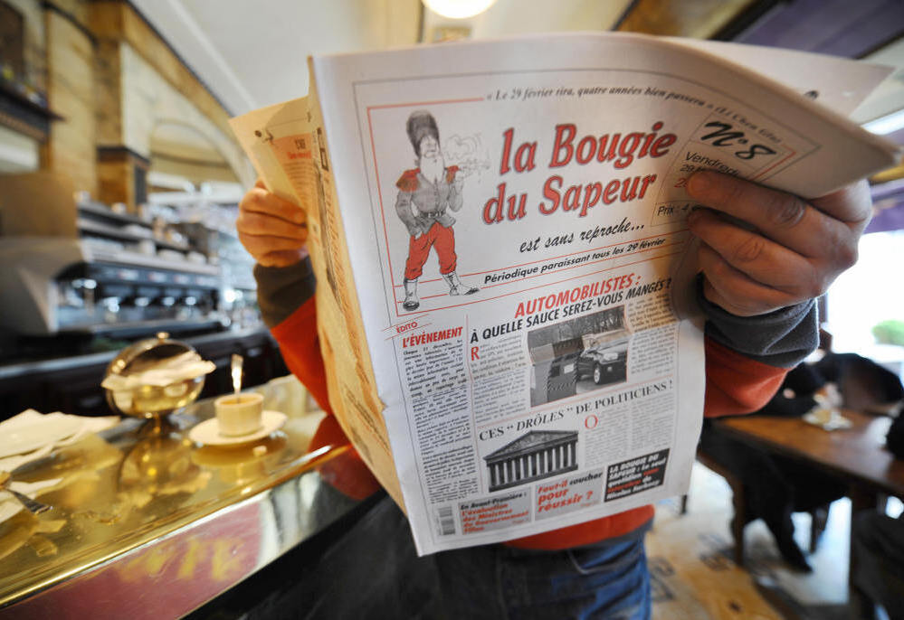 A man reads a copy of the satirical newspaper La Bougie du Sapeur (The Sapper's Candle), published every leap day, in a Parisian cafe on Feb. 29, 2008. The paper's tagline is "without reproach."