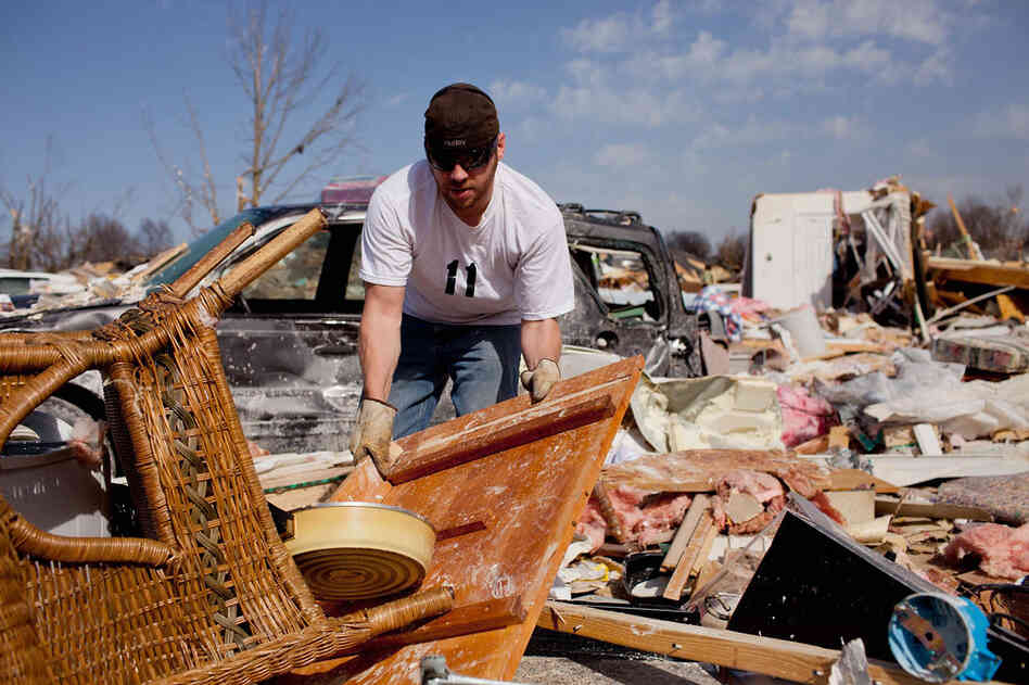 Douglas Osman sorts through debris at his grandmother's house in Harrisburg, Ill. Mary Osman was killed after the tornado hit. 