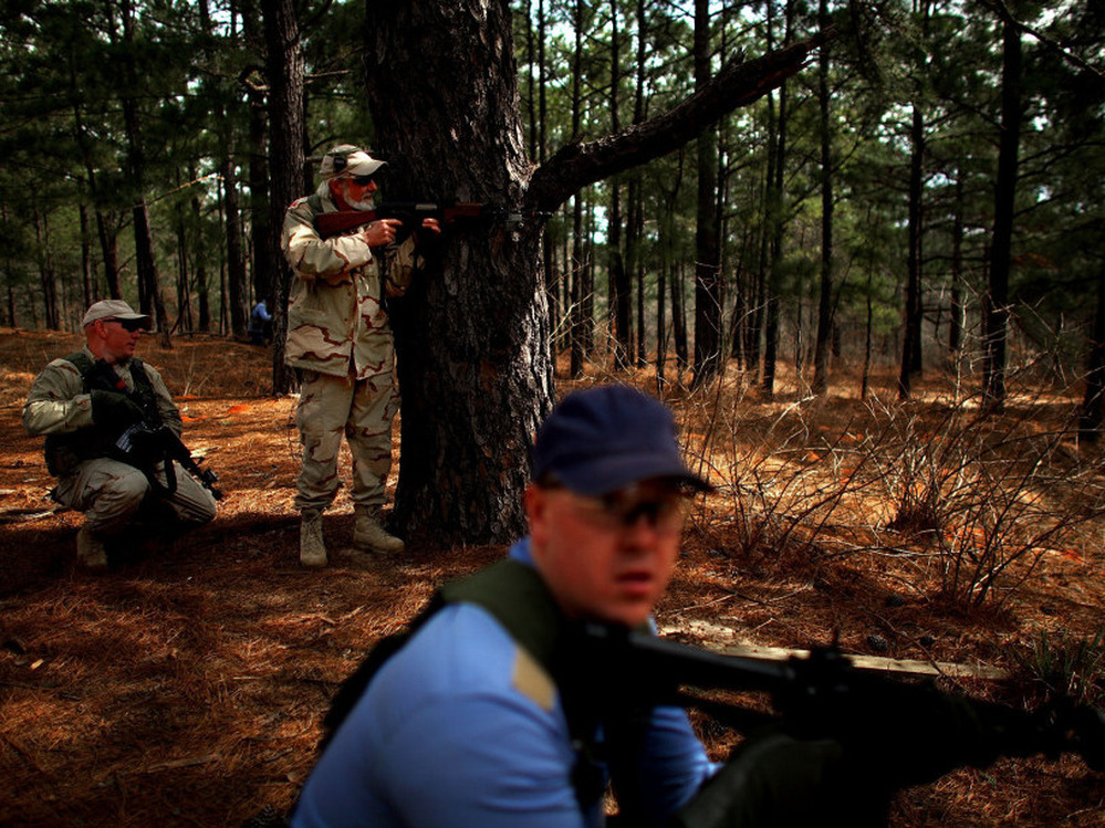 Role players from the Afghan National Army, in tan, and Afghan National Police, in blue, take up positions during a training exercise in a mock Afghan village in Fort Polk, La.