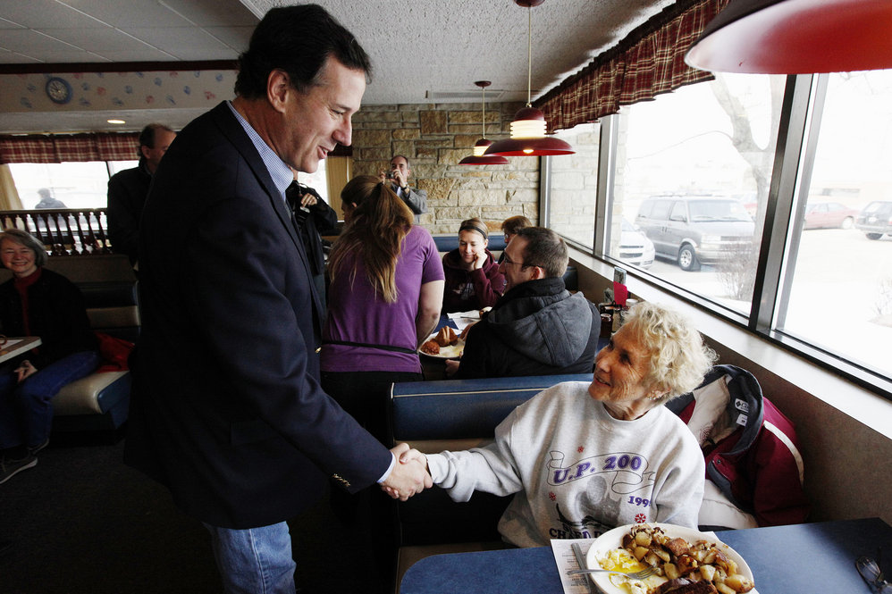 Santorum greets diners at New Beginnings Restaurant in Kentwood, Mich. He lost Tuesday but is atop polls in several states with March 6 primaries. 
