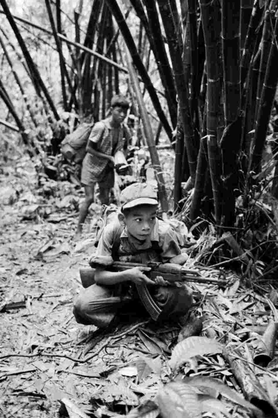 A 14-year-old Vietnamese boy points an AK-47 in 1968. The Vietnam War became the first large conflict in which both sides carried assault rifles. 