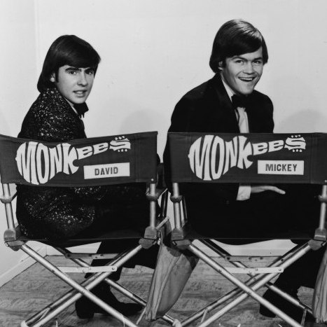 Promotional portrait of popular music and television group the Monkees, dressing in tuxedos and they as they sit in folding chair and look over their shoulders, early 1970s. From left, British musician and actor Davy Jones, and American musician and actors Mickey Dolenz, Peter Tork, and Michael Nesmith. 