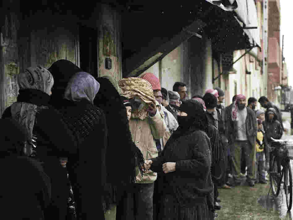 Syrians line up for bread outside a bakery in Qusayr on Thursday. After a month of heavy fighting in parts of Homs, civilians describe the conditions as miserable. 