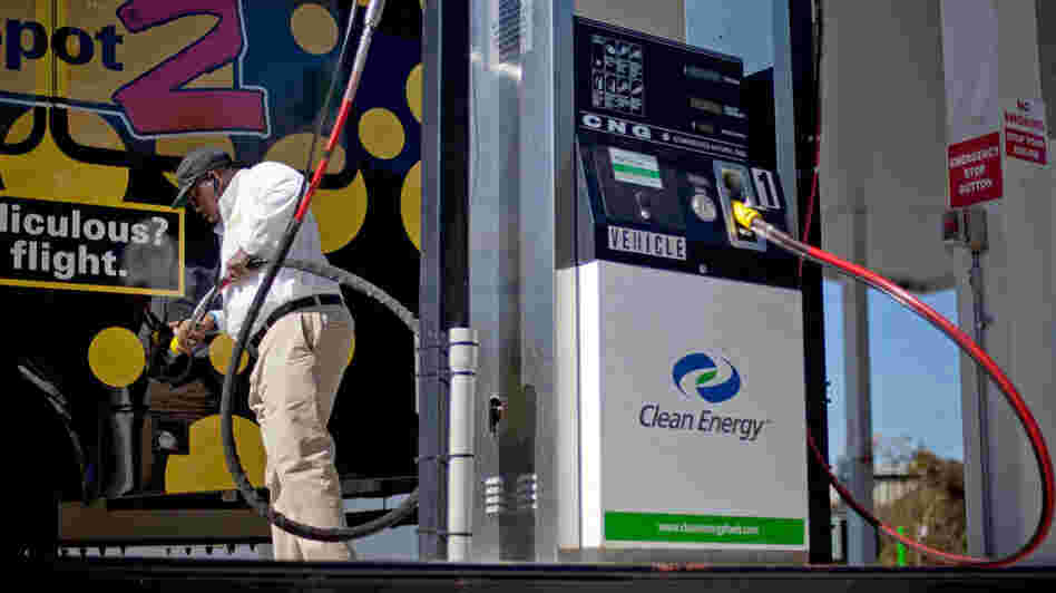 Bob Davis fills up his airport shuttle van at a natural gas pumping station in College Park, Ga. A growing number of companies are considering converting their vehicle fleets to natural gas.