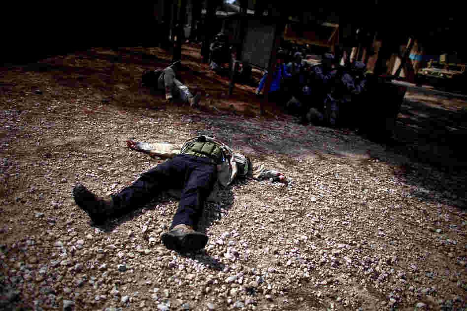 A mock suicide bomber plays dead in the middle of a shootout.