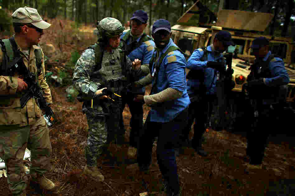 Role-players from the Afghan National Army, in tan, and Afghan National Police, in blue, help an injured American soldier.