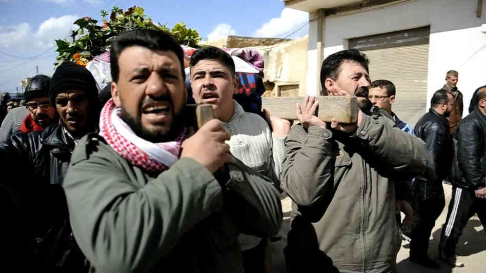 Syrian mourners on Wednesday carried the body of a man who was killed in fighting near Homs.