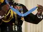 A military aide holds up the Congressional Medal of Honor. The 2005 Stolen Valor Act makes false claims about receiving military medals punishable by up to one year in prison.