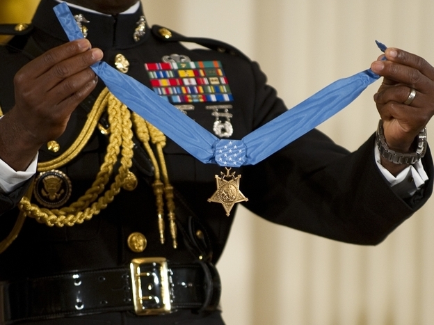 A military aide holds up the Congressional Medal of Honor. The 2005 Stolen Valor Act makes false claims about receiving military medals punishable by up to one year in prison.