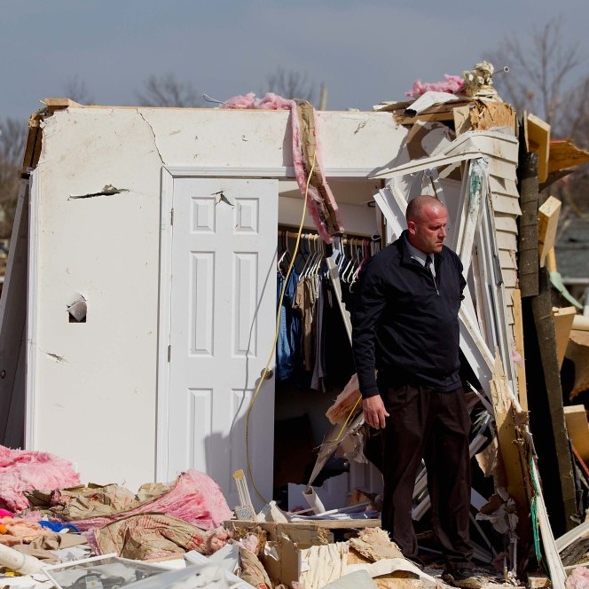 Steve McDonald stands in the debris from the home of his mother-in-law, Mary Osman, who died when a tornado touched down Wednesday in Harrisburg, Ill. She was one of five people killed on Brady Street.